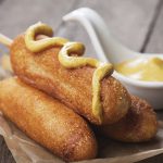 corn dog made from cornmeal topped with mustard