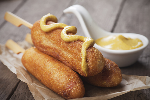 corn dog made from cornmeal topped with mustard