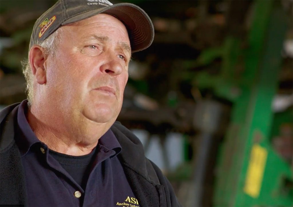 farmer Henry Denotter talking in front of farm equipment