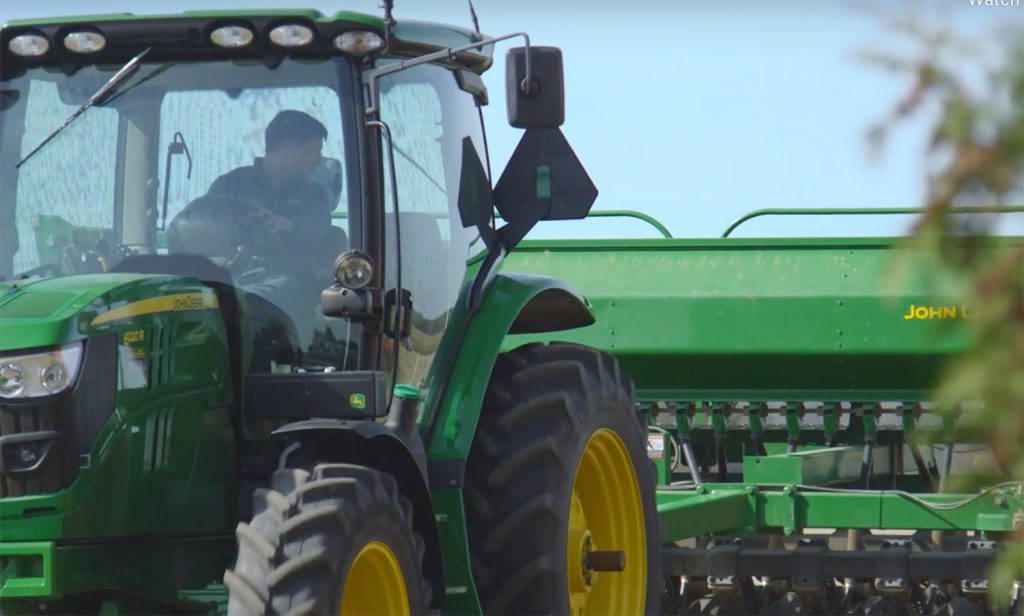 a man driving a green tractor