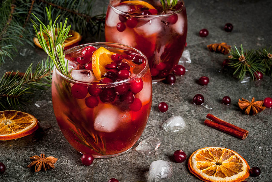 Holiday Cocktail with Ontario Whiskey cranberry, rosemary and garnished with oranges, cinnamon sticks and cranberries