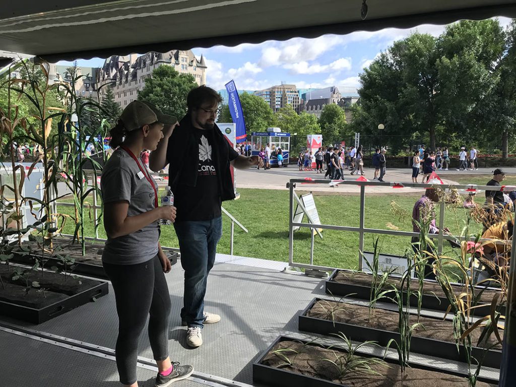 Women teaching Man about Corn. Grain Discovery Zone 2019 Ambassador talking about field crop props on Canada Day Parliament Hill