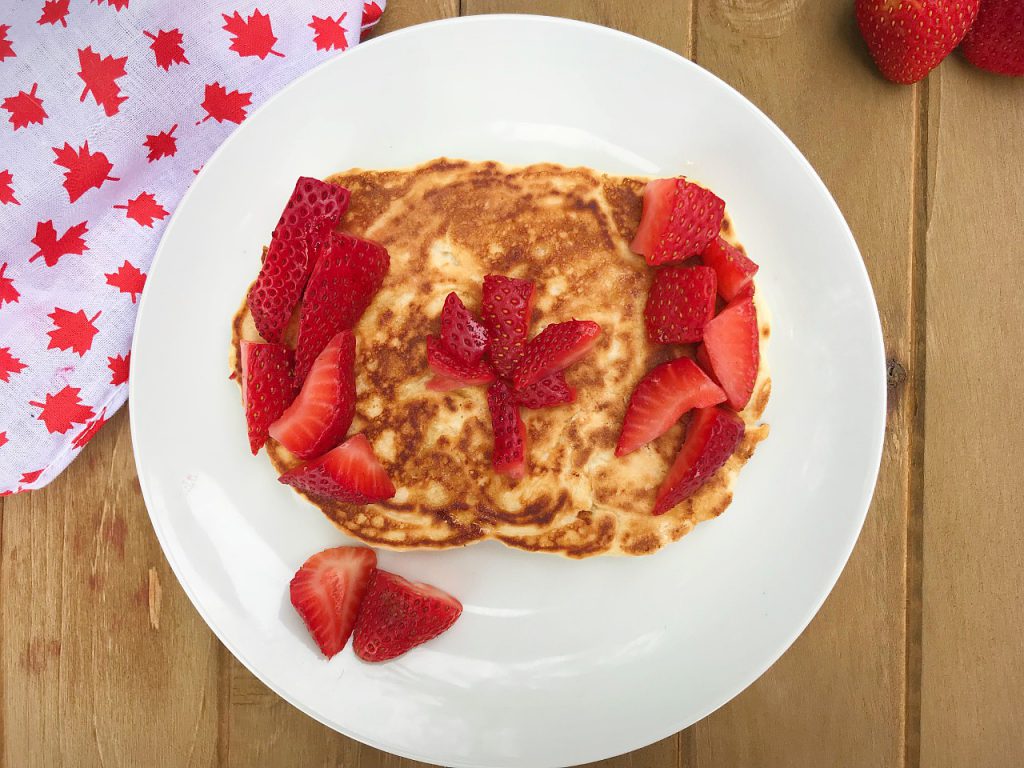 pancakes decorated to look like the Canadian flag using cut strawberries. 