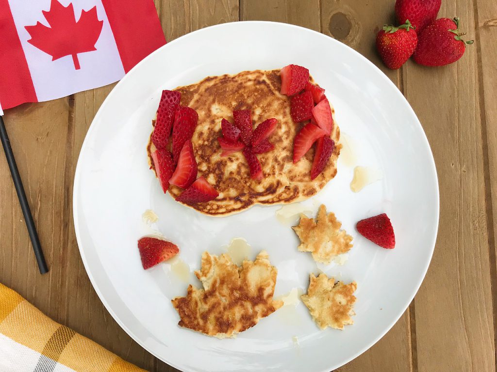 homemade whole wheat pancakes make into maple leaf shapes and the Canadian flag to celebrate Canada Day