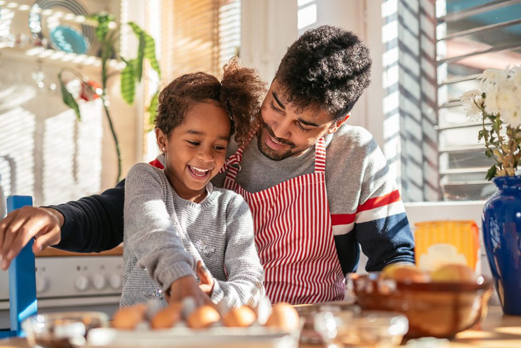 father and daughter baking together.