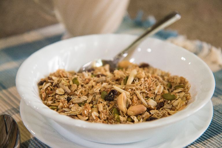 bowl of homemade whole grain granola featuring wheat bran, seeds and nuts. 