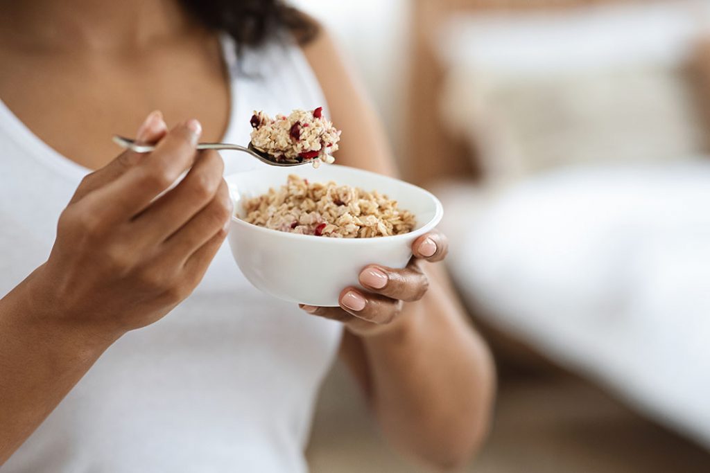 women eating a healthy breakfast of oatmeal and berries