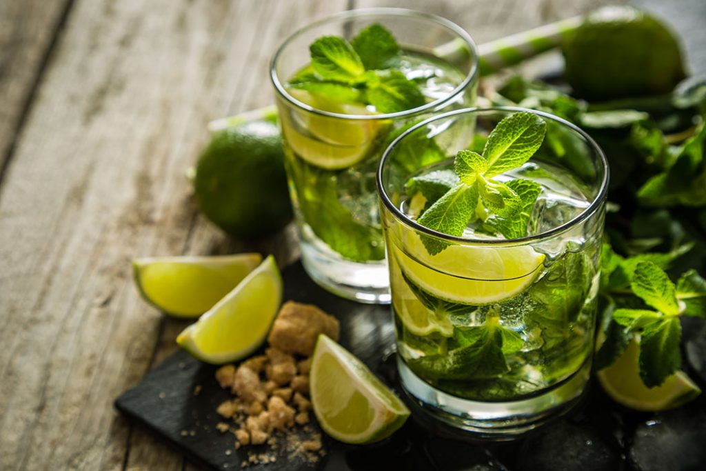 Mojito cocktail and ingredients, rustic wood background, copy space