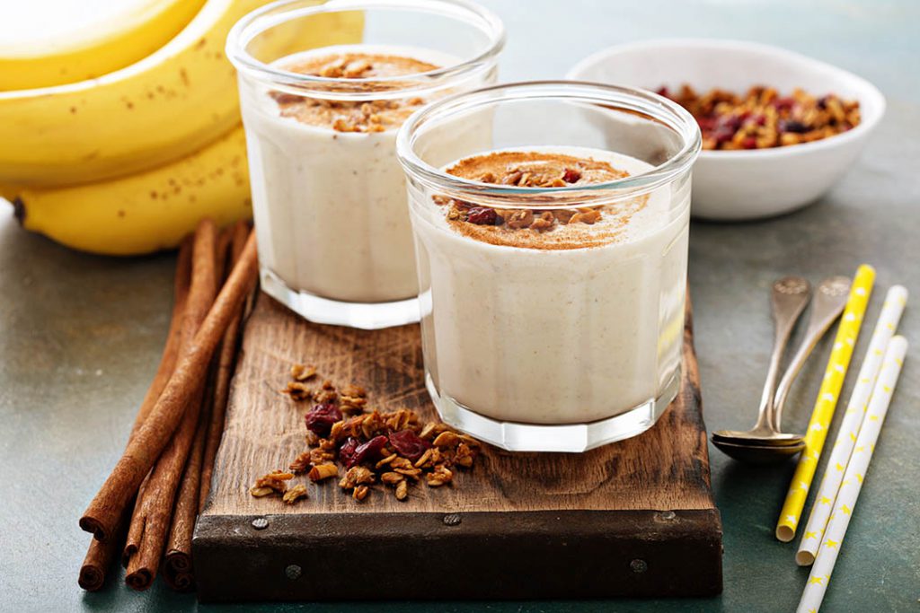 Banana smoothie with peanut butter, cinnamon and granola for healthy breakfast